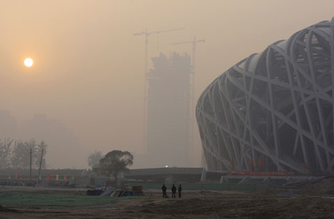 Buildings are shrouded in haze and smog nearby Beijing National Stadium. [File photo]